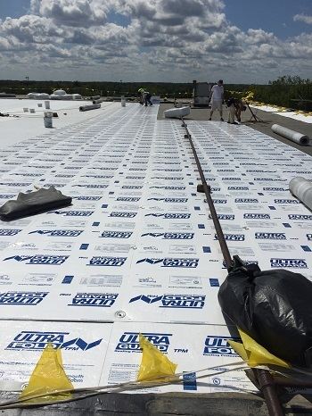 Watertown Industrial roofing contractors installing a new flat roof on a manufacturing plant